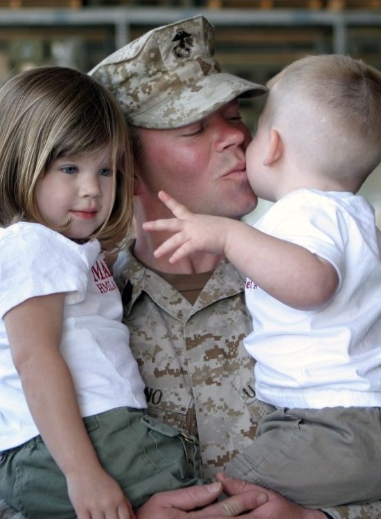Soldier kissing his children